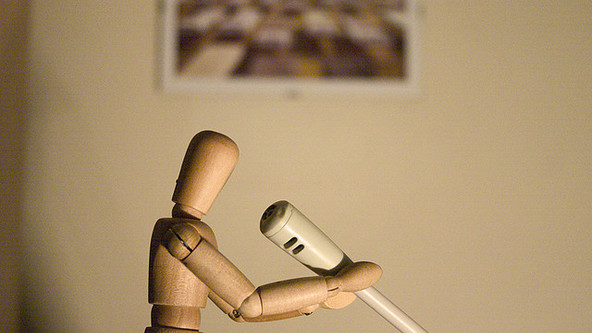 puppet holding desk microphone.